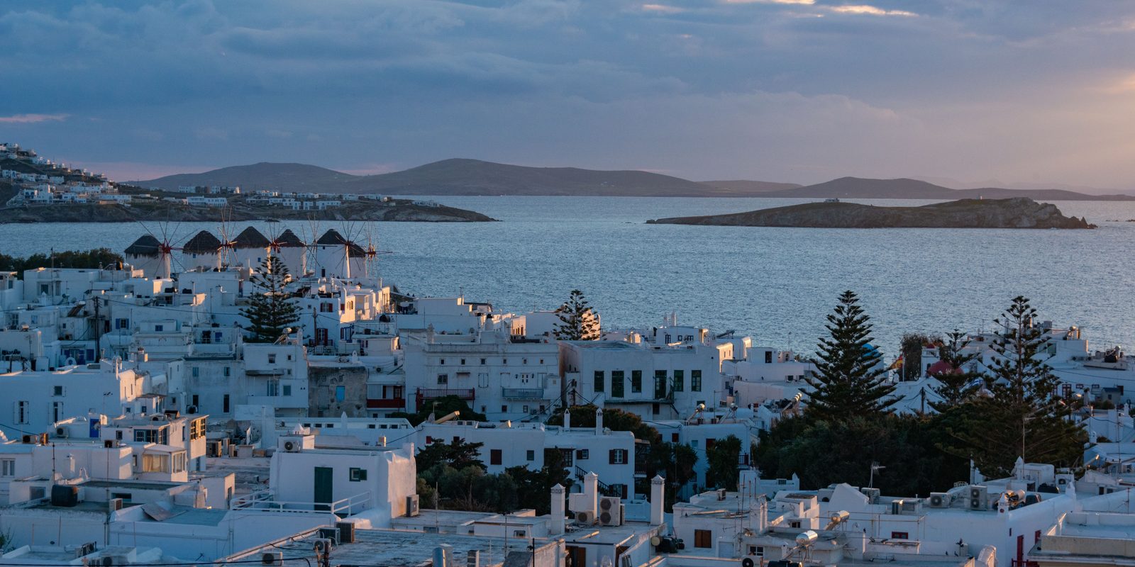 Whitewashed Greek island town of Mykonos above the Aegean sea at dusk