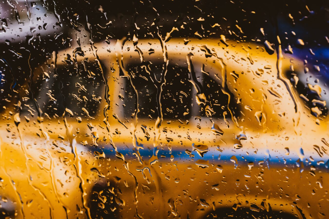 Raindrops on a car window during heavy urban rain